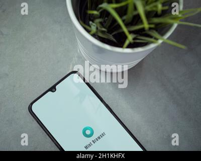 Lod, Israel - July 8, 2020: Modern minimalist office workspace with black mobile smartphone with Mint Browser app launch screen with logo on marble ba Stock Photo