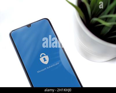 Lod, Israel - July 8, 2020: Modern minimalist office workspace with black mobile smartphone with Microsoft Authenticator app launch screen with logo o Stock Photo