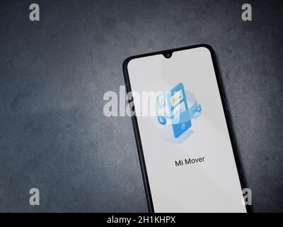 Lod, Israel - July 8, 2020: Mi Mover app launch screen with logo on the display of a black mobile smartphone on dark marble stone background. Top view Stock Photo