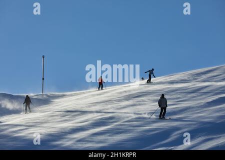 Skiing slope with many unrecognizable skiers coming down Stock Photo