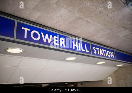 Landscape picture of the blue Tower Hill Station sign on the concrete ceiling over the entrance and with four lights behind it Stock Photo