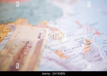 One hundred Cambodian riels banknote -with the number 100 in Khmer- next to Cambodia on a map of Southeast Asia Stock Photo