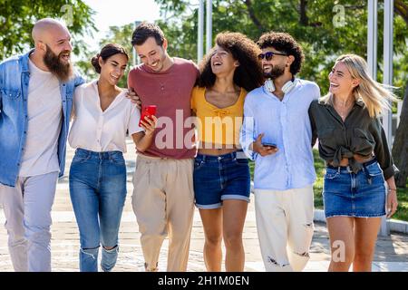 Happy diverse university students checking smart phones outdoors Stock Photo