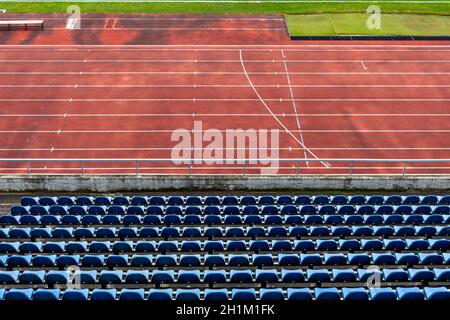 empty auditorium in athletic stadium, rows of blue chairs. Stock Photo