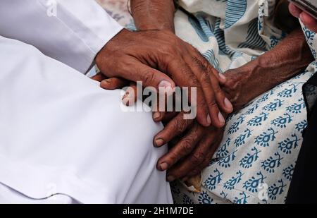 Hands, young and old, on top of each other, comforting each other, Kumrokhali, West Bengal, India Stock Photo