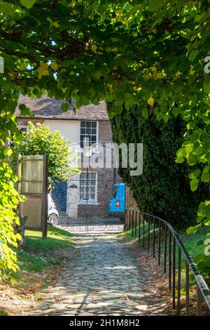 View of a cottage  from the churchyard in the village of Egerton, Kent, UK Stock Photo