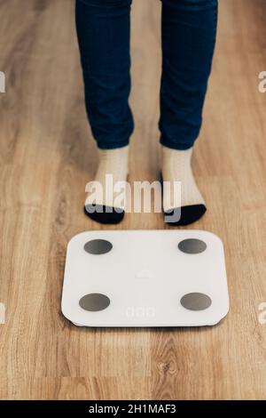 Modern Electronic Device. Girl Measures Weight on Smart Scales. Stock Photo