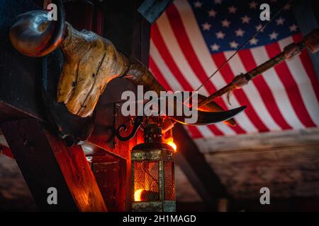 Aged grungy buffalo skull, retro lamps and bow on blurred American flag in the background. Halloween concept, background or texture in western style Stock Photo