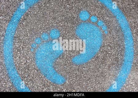 Sign painted on the pavement reminding users to maintain a physical distance of 3 feet / 1 meter during the COVID-19 pandemic. Stock Photo