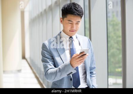 Businessman staring at his mobile phone Stock Photo