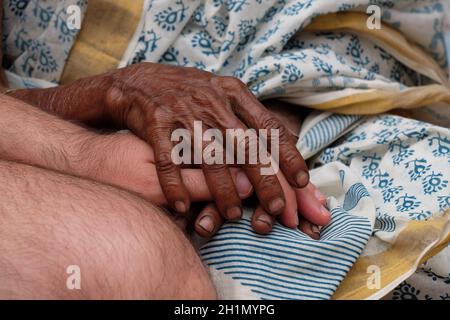 Hands, young and old, on top of each other, comforting each other, Kumrokhali, West Bengal, India Stock Photo