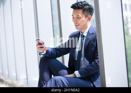 Businessman staring at his mobile phone Stock Photo