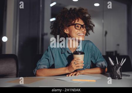 Happy Afro American woman in glasses working at workplace Stock Photo