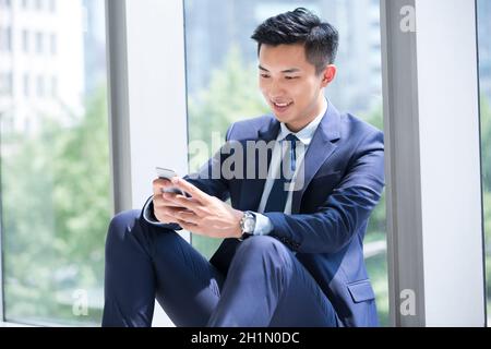 Businessman staring at his mobile phone Stock Photo