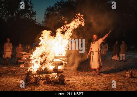 Cedynia, Poland, June 2019 Pagan reenactment of Kupala Night, called in Poland Noc Kupaly, shaman greeting strangers with knife at bonfire. Slavic hol Stock Photo