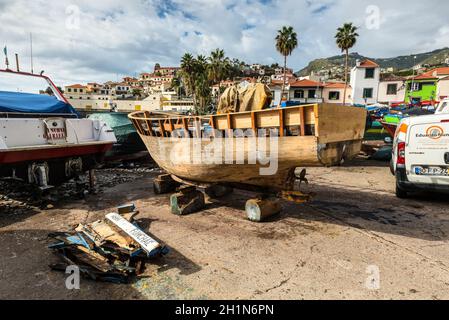 Camara de Lobos, Madeira, Portugal - December 10, 2016: Wooden fishing boat on the shore of fishing village Camara de Lobos near Funchal, Madeira Isla Stock Photo