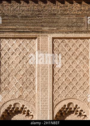 Ali ben Youssef Madrasa exterior islamic symbols, calligraphy and sacred geometry carved on the wall in Marrakesh, Morocco Stock Photo