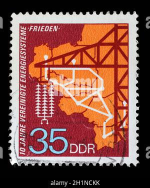 Stamp issued in Germany - Democratic Republic (DDR) shows High-tension mast, 10 Years Of United Energy Systems, circa 1973. Stock Photo