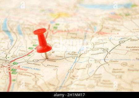 A red pin pressed into a map detailing a point of interest. Stock Photo