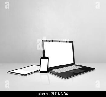 Laptop, mobile phone and digital tablet pc on white concrete office desk. 3D Illustration Stock Photo