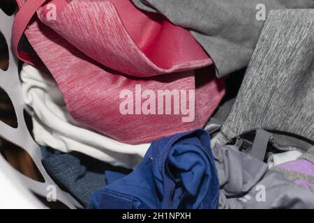 Close up of vivid pink, blue and grey clothes in a laundry basket Stock Photo