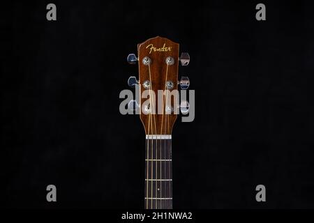 Fender acoustic guitar head with chrome tuning pegs and fretboard on isolated black background Stock Photo