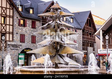 Saint Lary Soulan, France - December 26, 2020: fountain in the city center frozen by the cold on a winter day Stock Photo