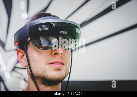 Young man is using virtual reality glasses or headset Stock Photo
