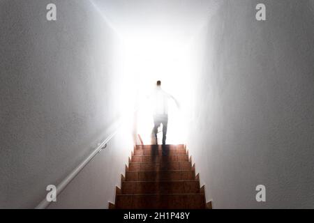 Man is going up on basement stairs with balustrade. Natural bright sunlight. Stock Photo