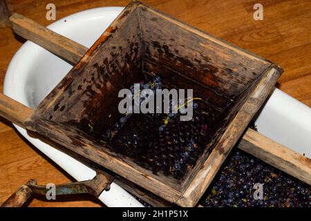 Manual mechanism for crushing grapes. Crush the grapes into juice and wine. Stock Photo