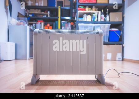 Electric heater, heating the basement. Blurry shelfs in the background Stock Photo