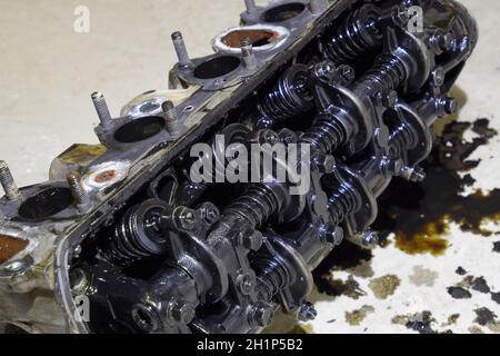 The head of the block of cylinders. The head of the block of cylinders removed from the engine for repair. Parts in engine oil. Car engine repair in t Stock Photo