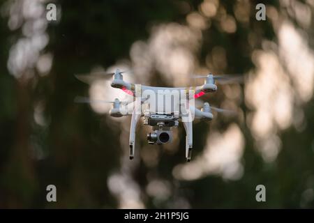 2 - Quad rotor drone hovering mid air for videography or photography. Commercially available remote control aircraft with gimbal stabilisation Stock Photo