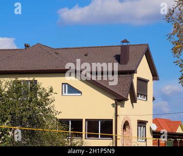 Decorative metal tile on a roof. Types of a roof of roofs. Decorative metal on the roof of the house. Stock Photo