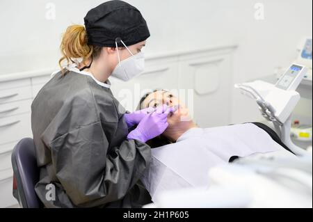 Young dentist working with female patient in a modern hospital. High quality photo Stock Photo
