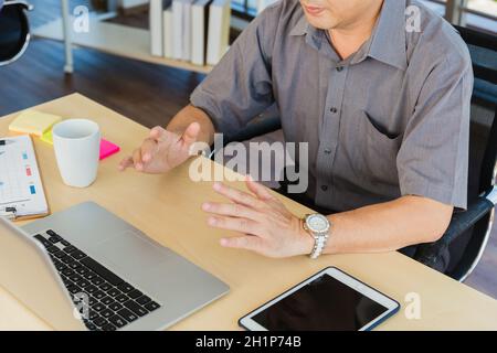 Asian senior business man working online on a modern laptop computer he looking at the screen for remote online studying. Old businessman people using Stock Photo
