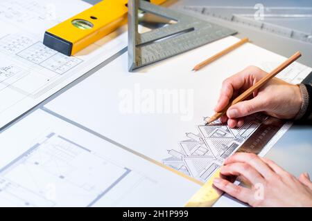 Macro close up of architect planning home layout with pencil. Stock Photo