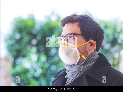 Young man outdoors with a breathing mask. Flue and corona season. Stock Photo