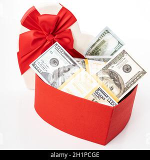 Bundle of dollars in heart gift box with bow isolated on white Stock Photo