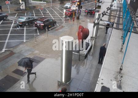 Pedestrians stroll on a rain-soaked day on Sherbrooke Street in Montreal, Quebec, Canada, near the Montreal Museum of Fine Arts. Stock Photo