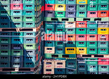 Containers with bottles of beer in warehouse. Rows of plastic crates. Stock Photo