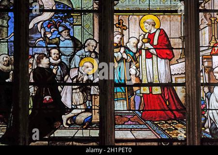 St. Aloysius Gonzaga receiving first communion from the hands of Saint Charles Borromeo, stained glass window in Saint Severin church in Paris, France Stock Photo