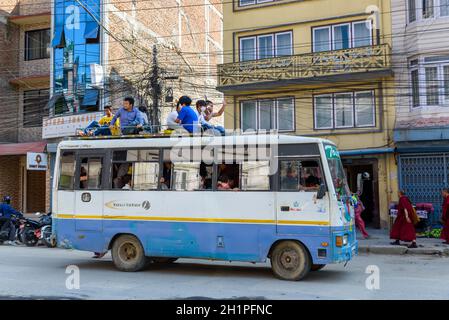 KATHMANDU, NEPAL - CIRCA NOVEMBER 2015: Men travel on top of a bus. Traveling on bus tops was authorized for a few months because of fuel shortage fol Stock Photo