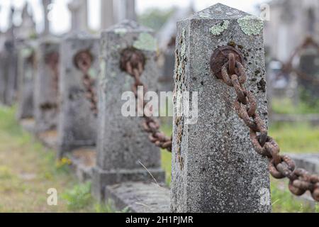 Old rusty chain connected to a concrete post Stock Photo
