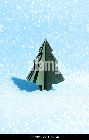 Christmas tree made of paper on a shiny blue background. Crafts by hand. Card Stock Photo