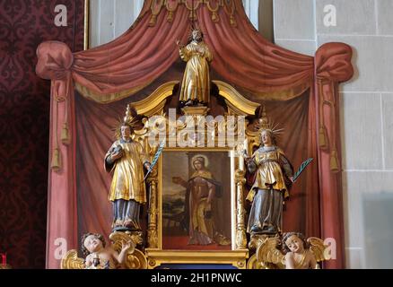 Saint Verena surrounded by the statues of Saints, altar of Saint Maurice in the church of St. Leodegar in Lucerne, Switzerland Stock Photo