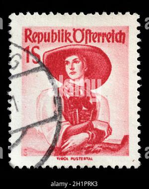 Stamp printed in Austria, shows a woman in national dress, Tirol, Pustertal, circa 1949 Stock Photo
