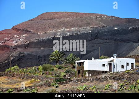 Beautiful volcanic landscape with a white house in front. Lanzarote, Canary Islands, Spain. Caldera de Masion near Femés. Image taken from public grou Stock Photo