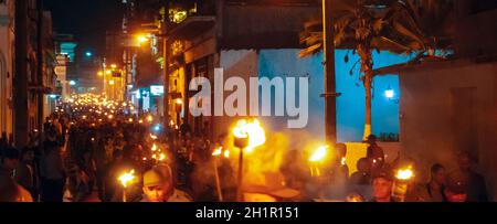 Santa Clara, Cuba - January 27 2019: Thousands of people marching down the street holding in their hands torches lit at night Stock Photo