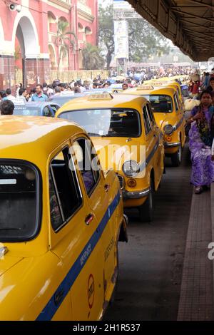 Yellow Kolkata taxis outside Howrah Railway Station in morning rush hour, Howrah, Kolkata, India Stock Photo